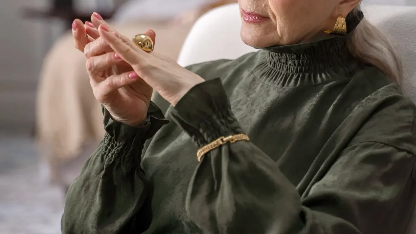 old woman admiring her gold ring